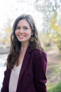 Lyndsey standing in her burgundy blazer and pink shirt